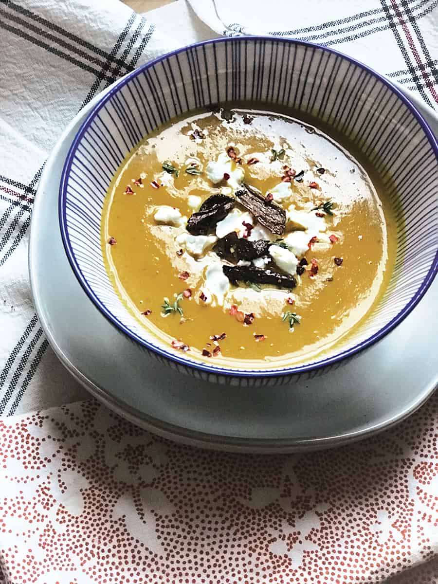 A bowl of kabocha squash soup and some cloth napkins.