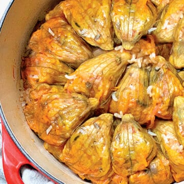 A red pot filled with stuffed zucchini flowers.