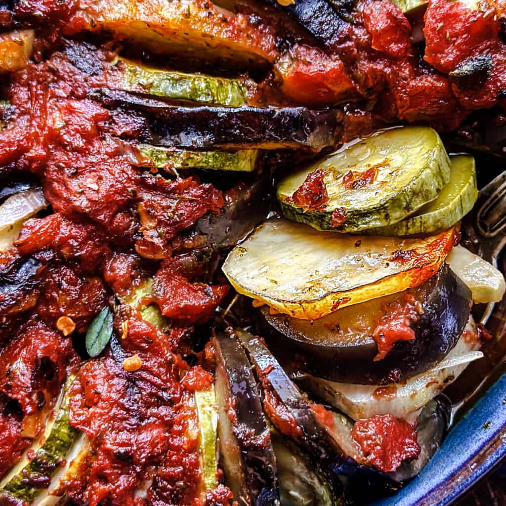 Close up of Greek roasted vegetables in a baking pan.