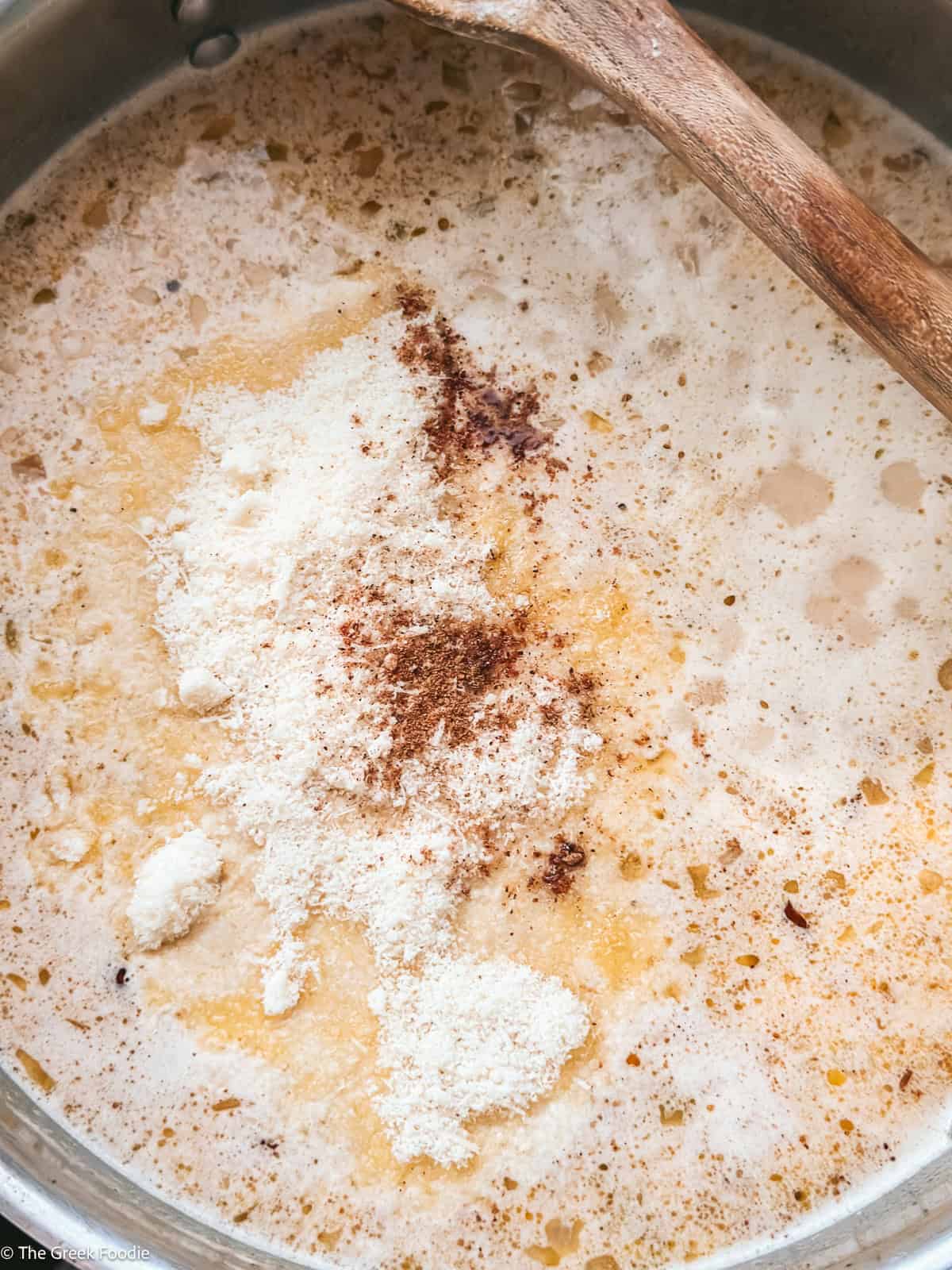 Creamy gravy sauce with Parmesan cheese and spices added to the pan for turkey meatballs.