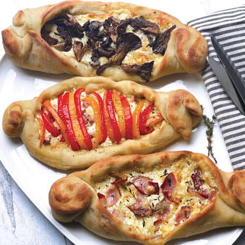 Three pizza boats, peinirli on a platter.