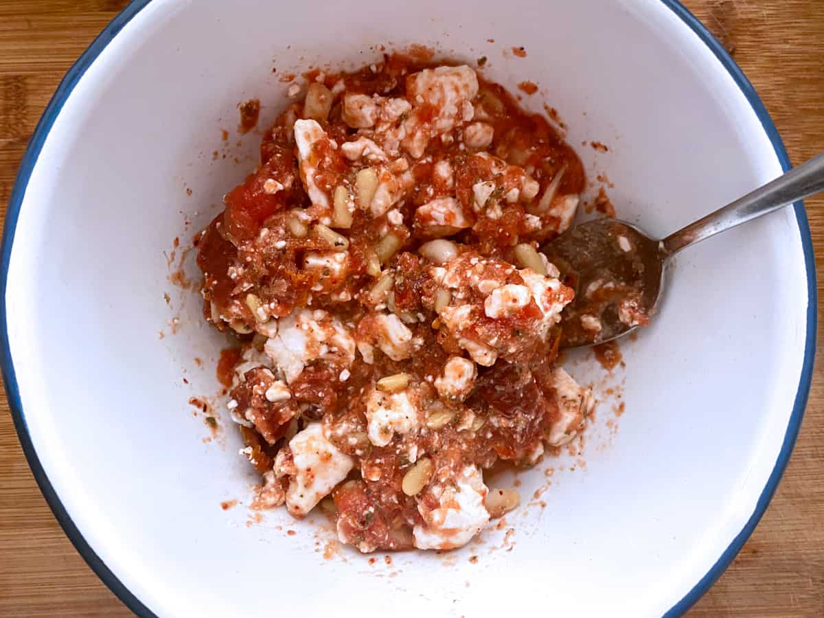 A bowl with a tomato and feta mixture.