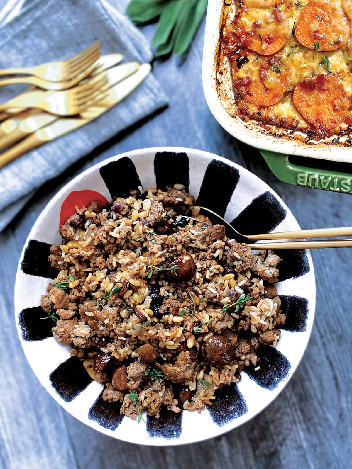 A bowl with turkey stuffing next to a sweet potato gratin.