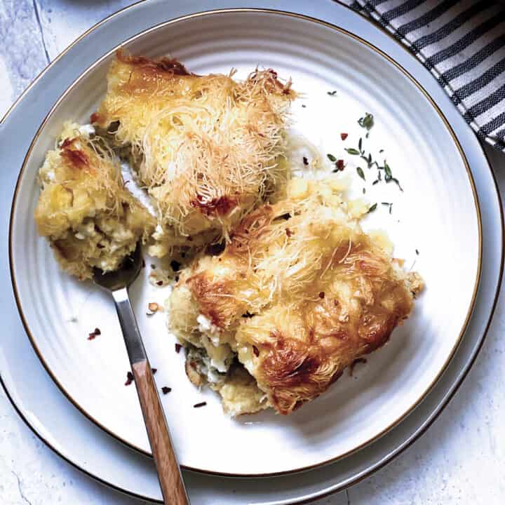 Two pieces of cheese pie on a plate with utensils.