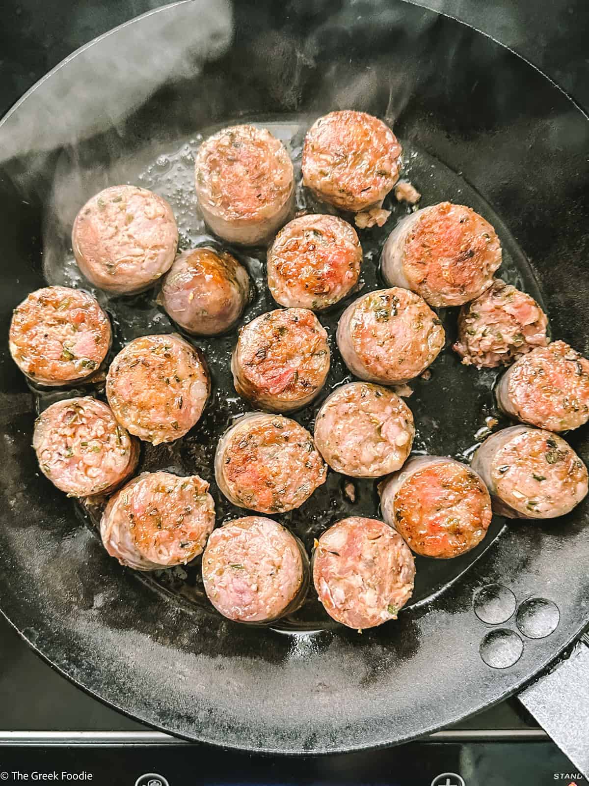 Sausage browning in a cast iron skillet
