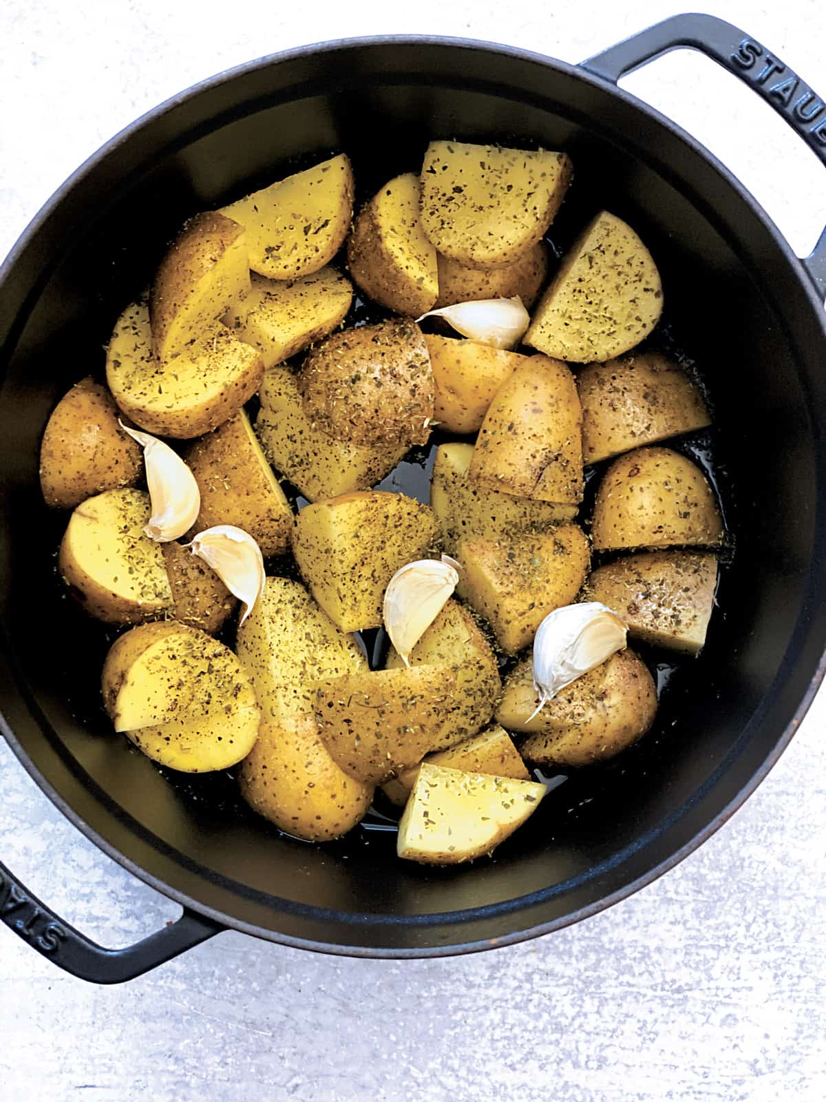 Cut up potatoes in a black pot, seasoned with olive oil and dry oregano.