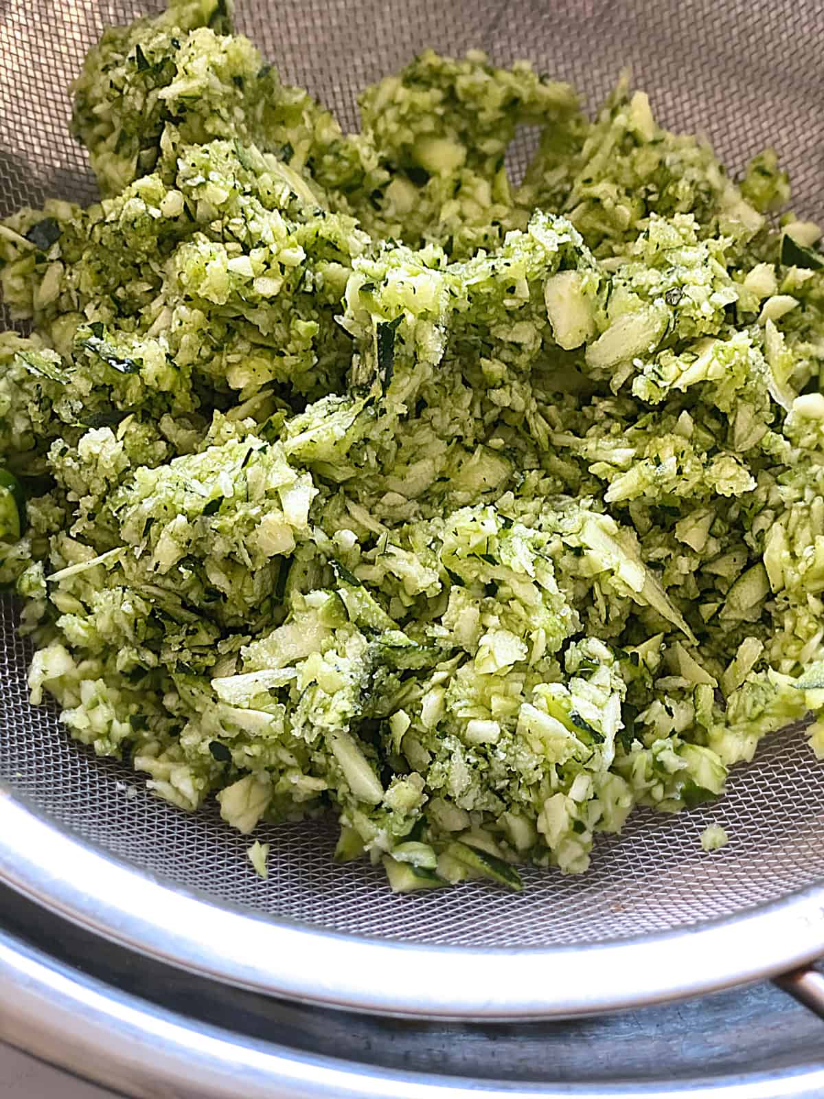 Grated zucchini on a colander.