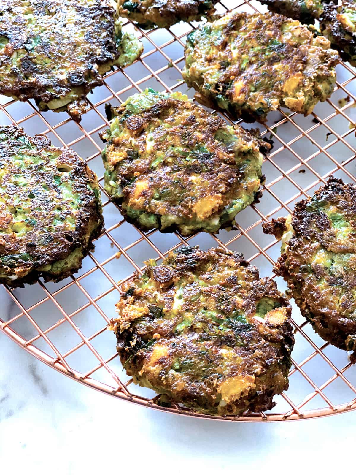 Zucchini pancakes on a wire rack.