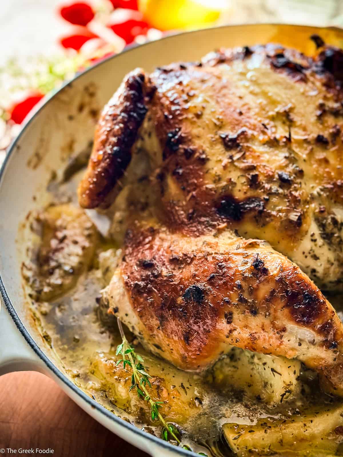 A crispy skin Greek spatchcock chicken with potatoes, lemon and herbs ready for serving