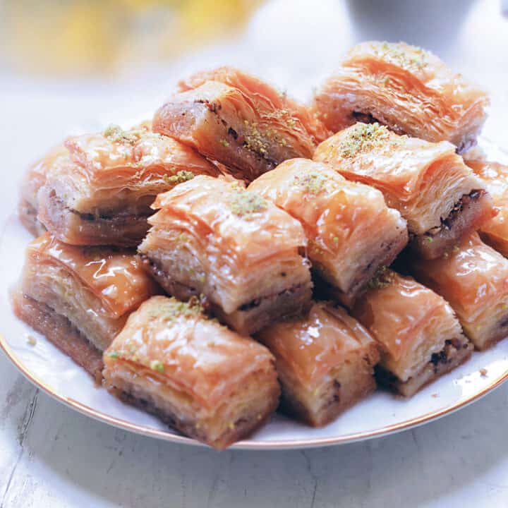 A serving plate with pistachio baklava pieces.