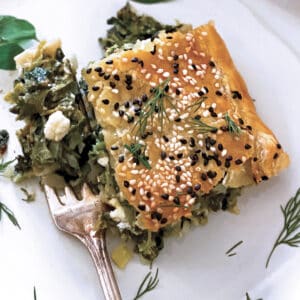 A piece of Greek Savory Pie in a white plate and a fork.