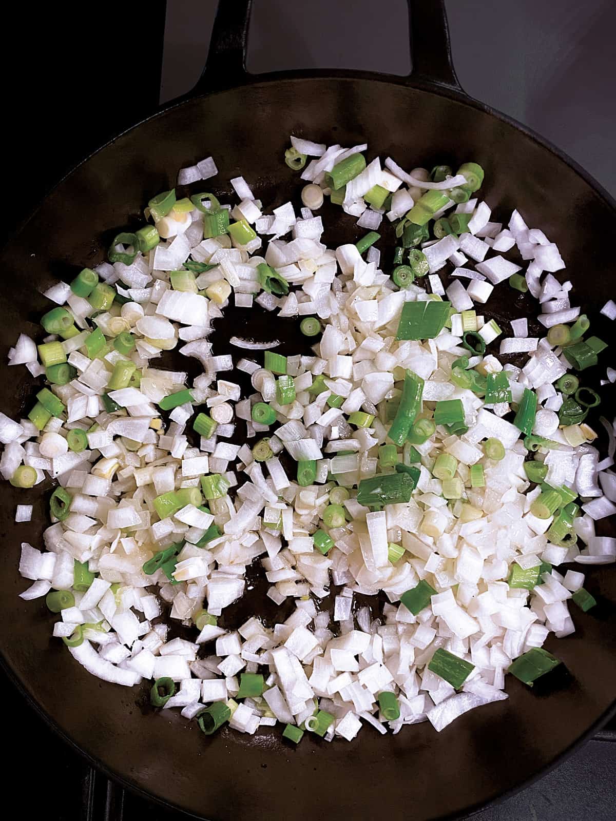 Diced onion and scallions in a pan.