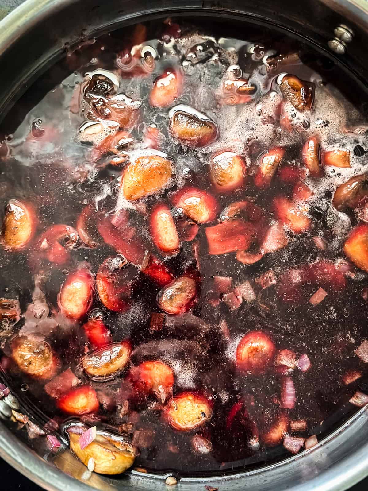 Mushrooms in red wine sauce in a skillet.
