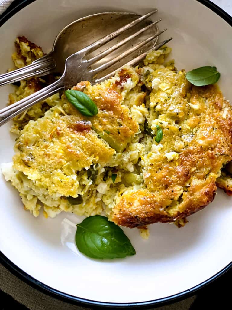 A piece of zucchini pie without the phyllo with grated zucchini, feta, eggs and herbs baked until golden