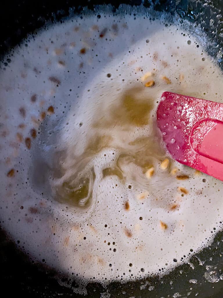 Melted butter in a pan and a red spatula.