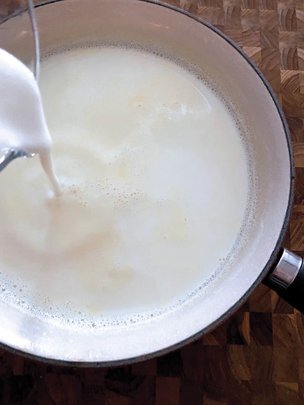 Milk being poured in a sauce pan.