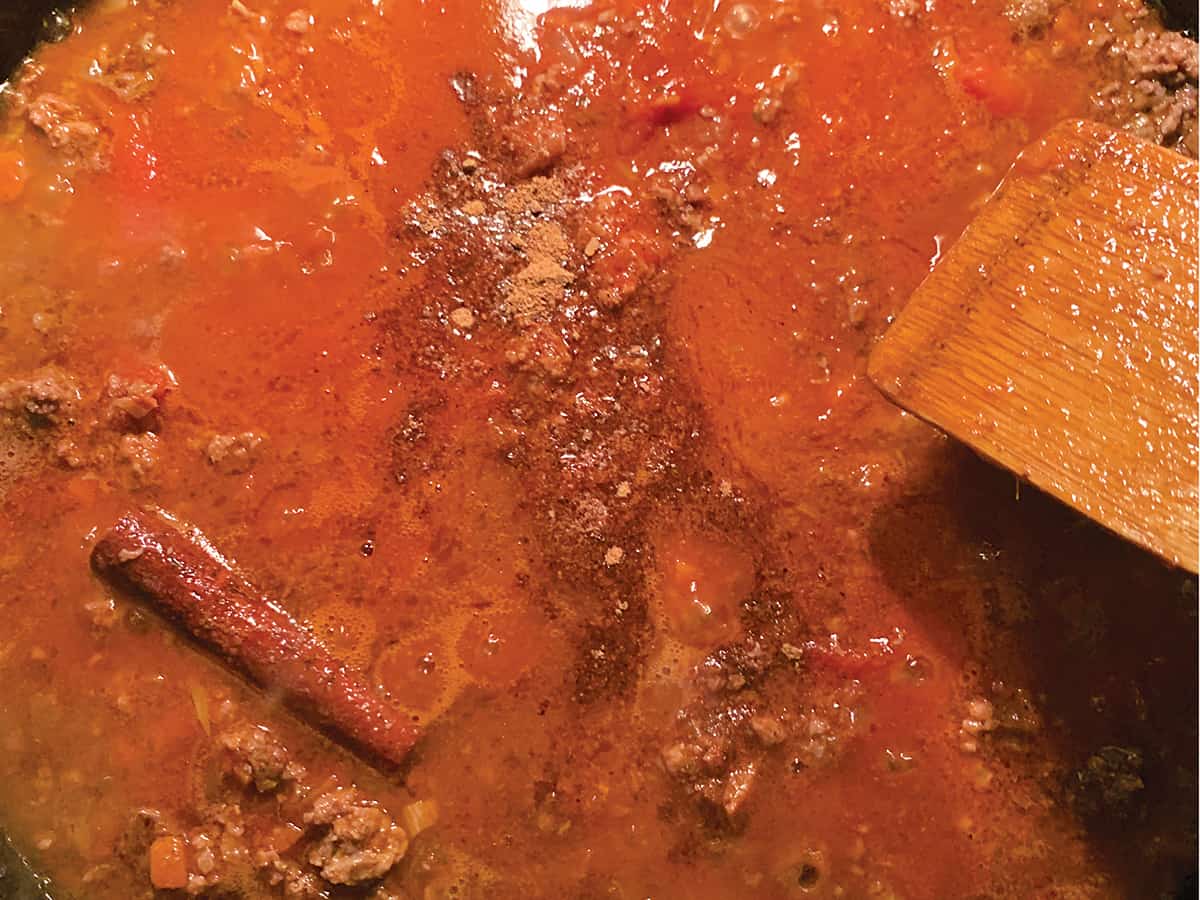 Ground meat, in a red sauce with a cinnamon stick.
