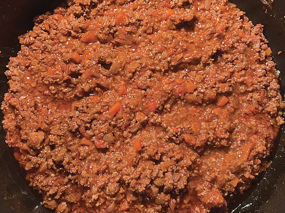 Greek bolognese sauce with diced carrots in a pot.