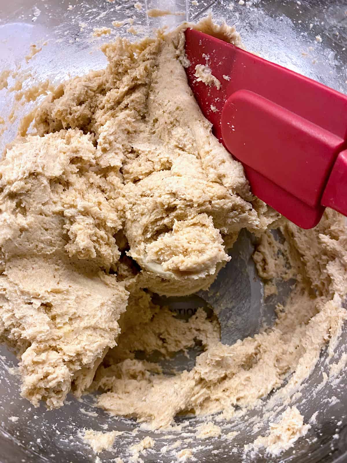 Savory galette dough in a food processor and a red spatula.