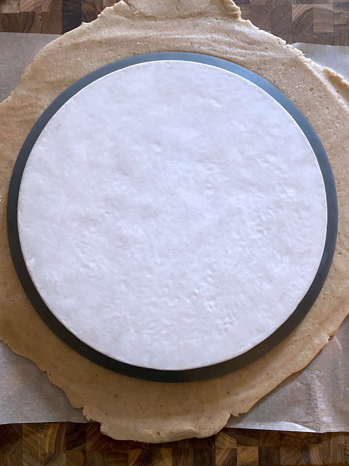 A plate on pie dough on a working surface.