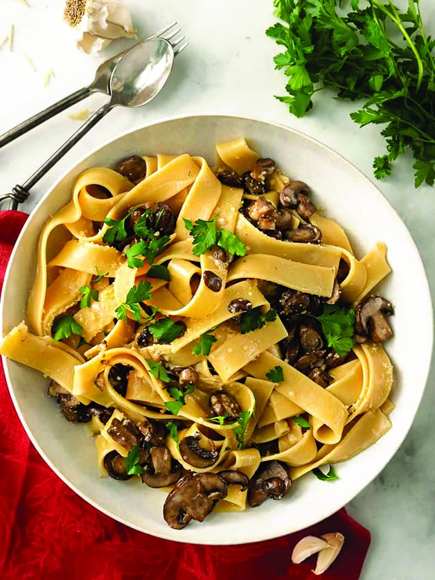 A plate with papardele pasta with mushrooms. 