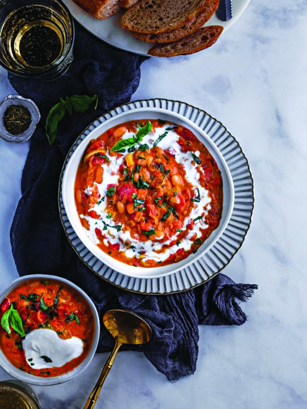 A bowl with bean and tomato basil soip.