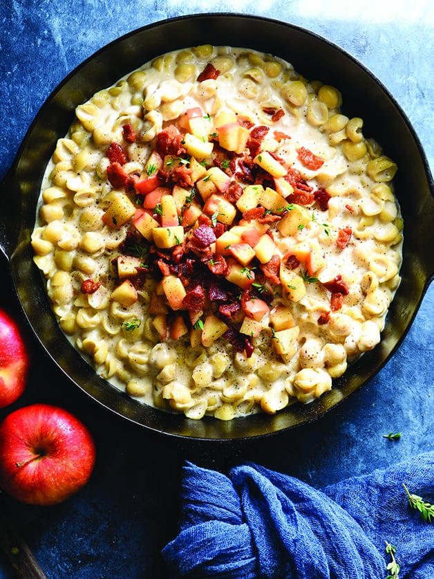 A skillet with macaroni and cheese with bacon and apples.