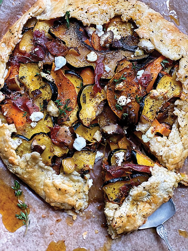 A squash galette with prosciutto and maple syrup on parchment paper.