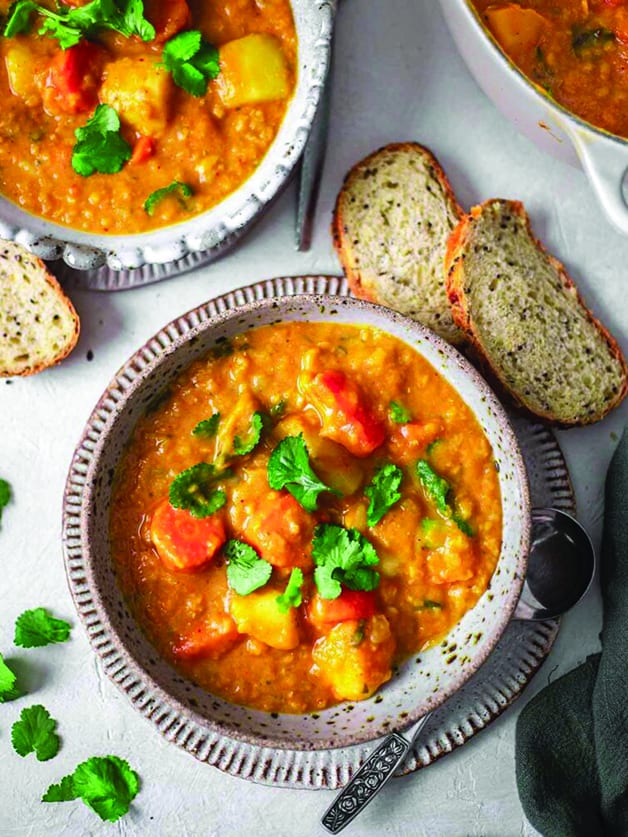 A bowl with Thai red curry potato lentil soup.