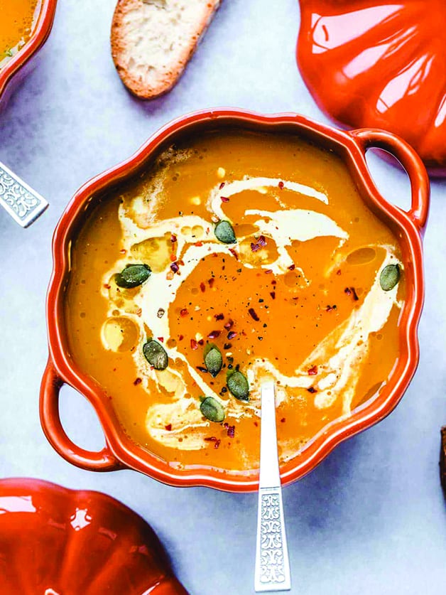 A pumpkin shaped bowl with vegan pumpkin soup.