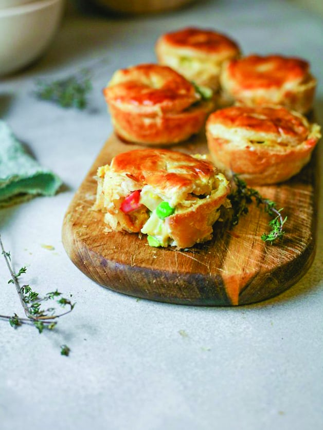 Mini pot pies on a wooden block.