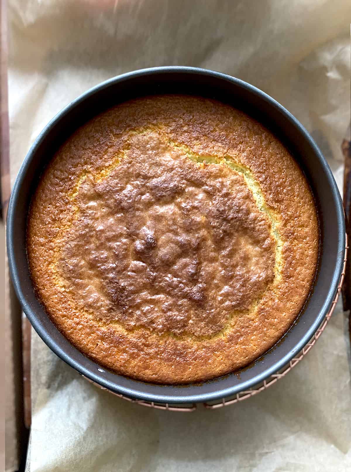 A baking pan with baked cake on a paper lined baking sheet.