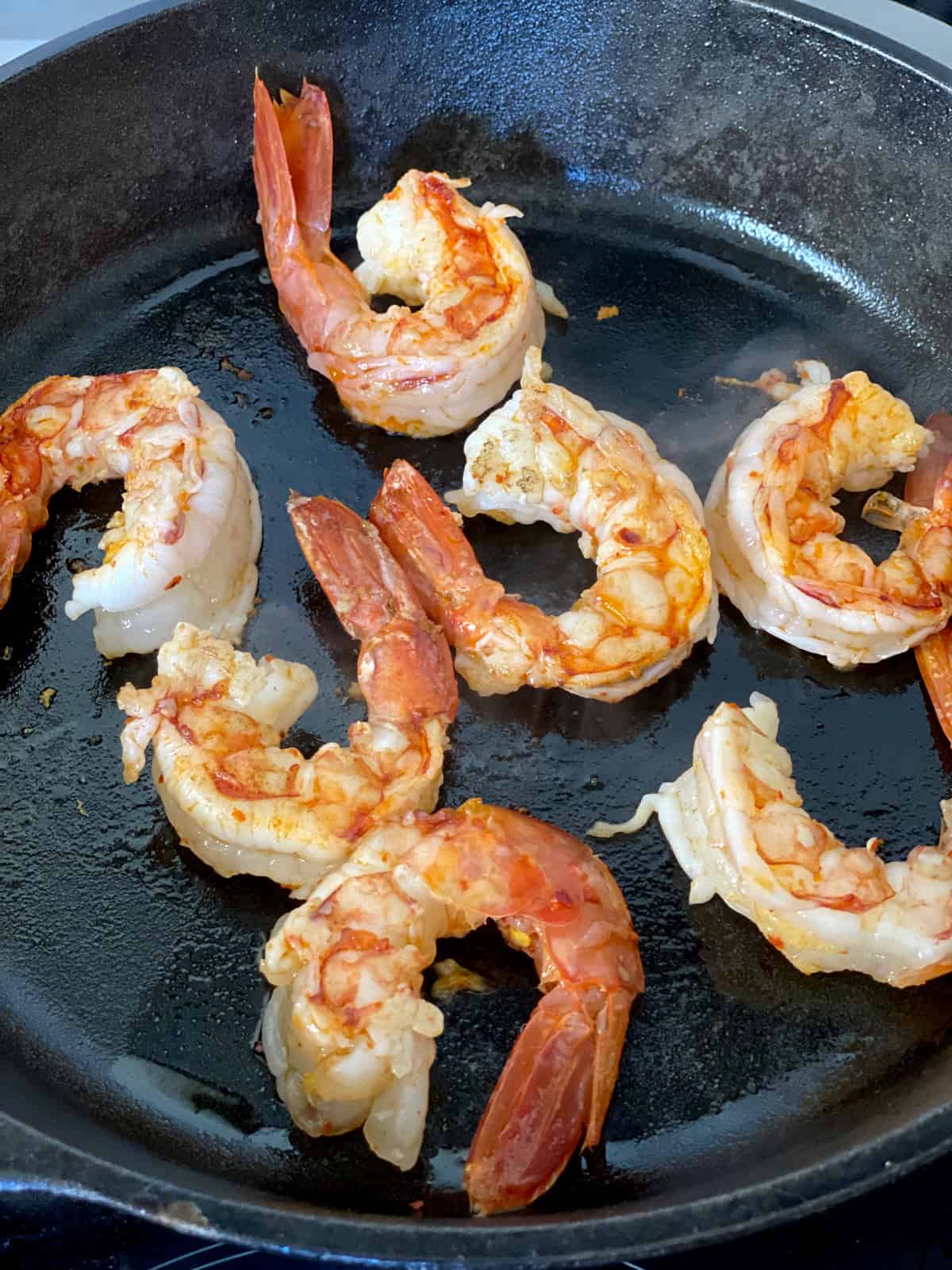 Shrimp sautéing in a skillet.