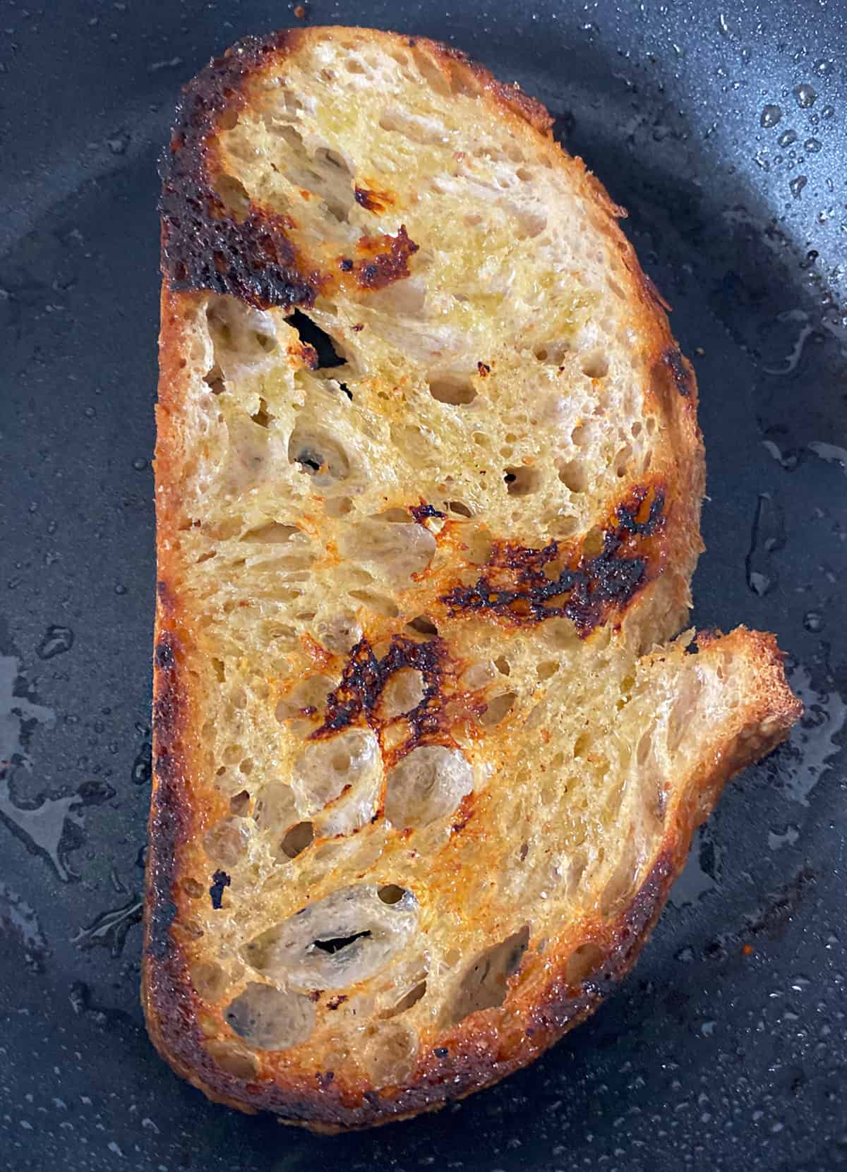 A piece of toasted bread in a skillet.