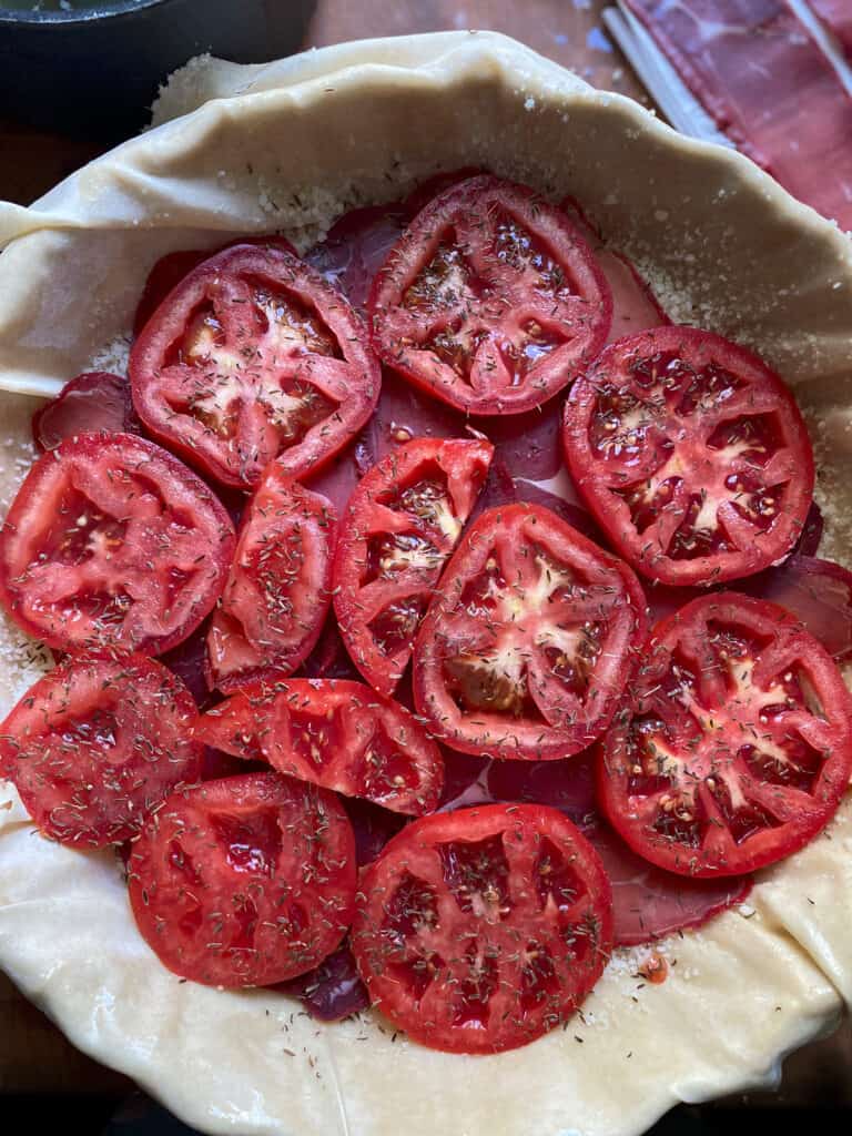 Tomato slices on top of phyllo sheets in a baking pan.