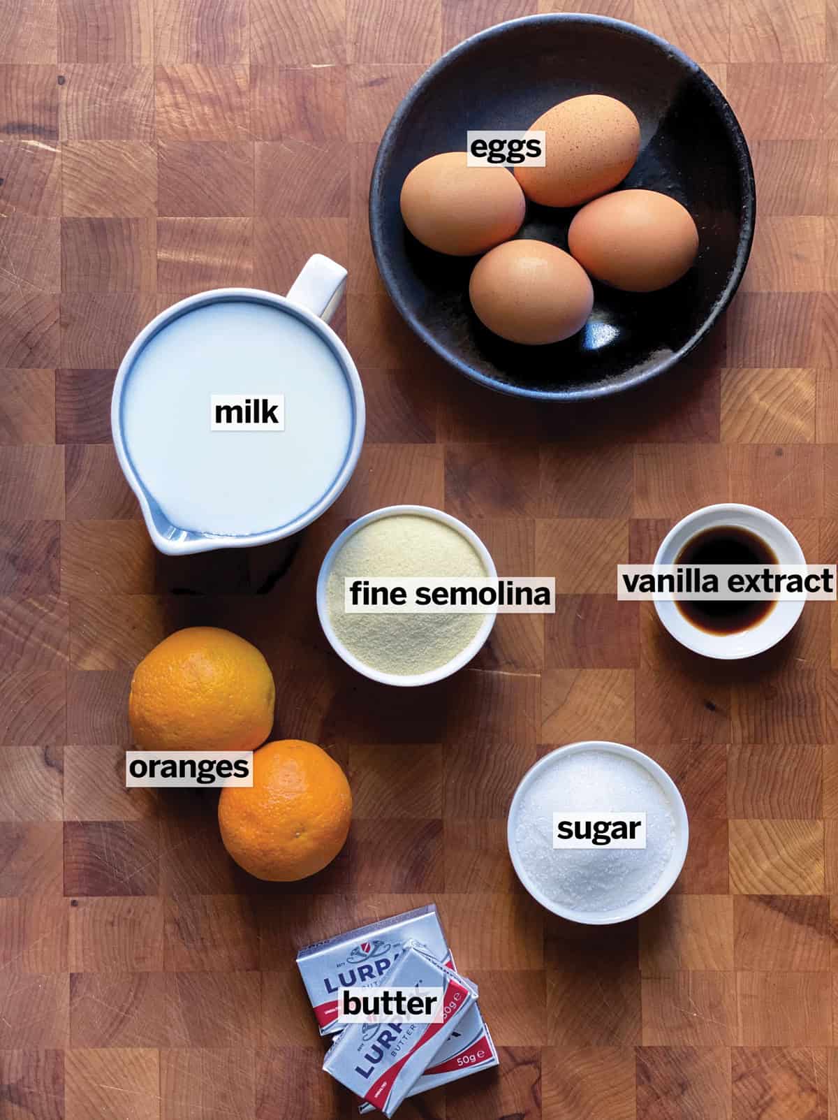 Ingredients for galatopita: whole milk, fine semolina, sugar, butter, eggs, vanilla, and an orange