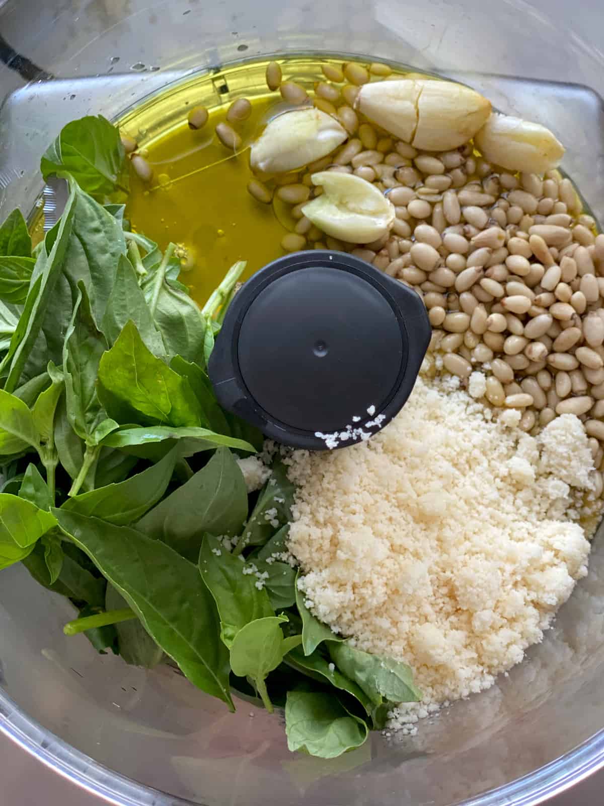 Pesto ingredients in a food processor.