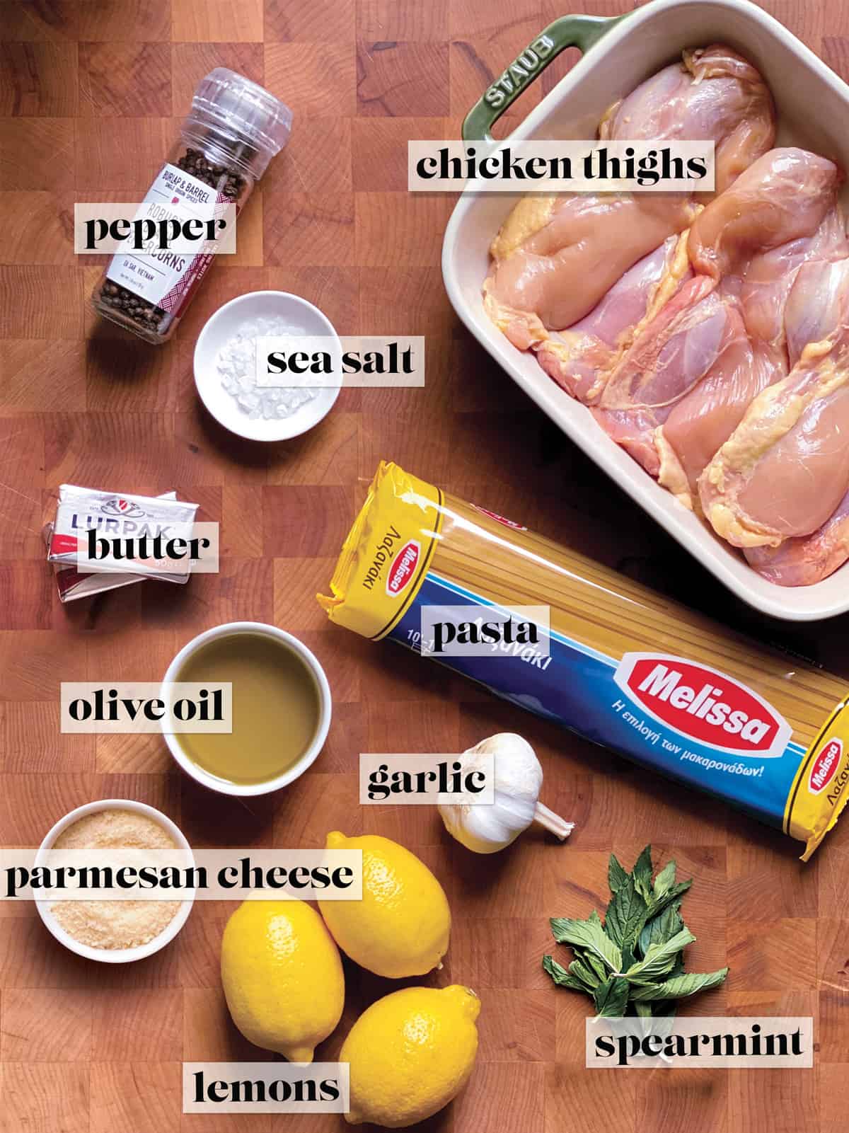 All the ingredients for making lemon chicken pasta on a butcher block.