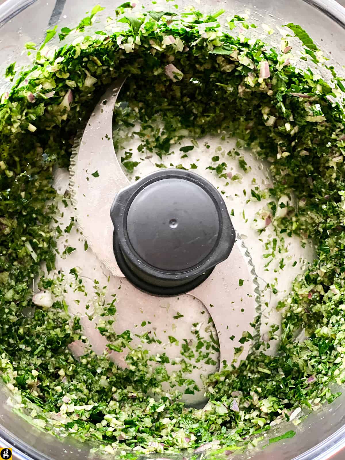Finely chopped herbs, onion, and garlic in a food processor.