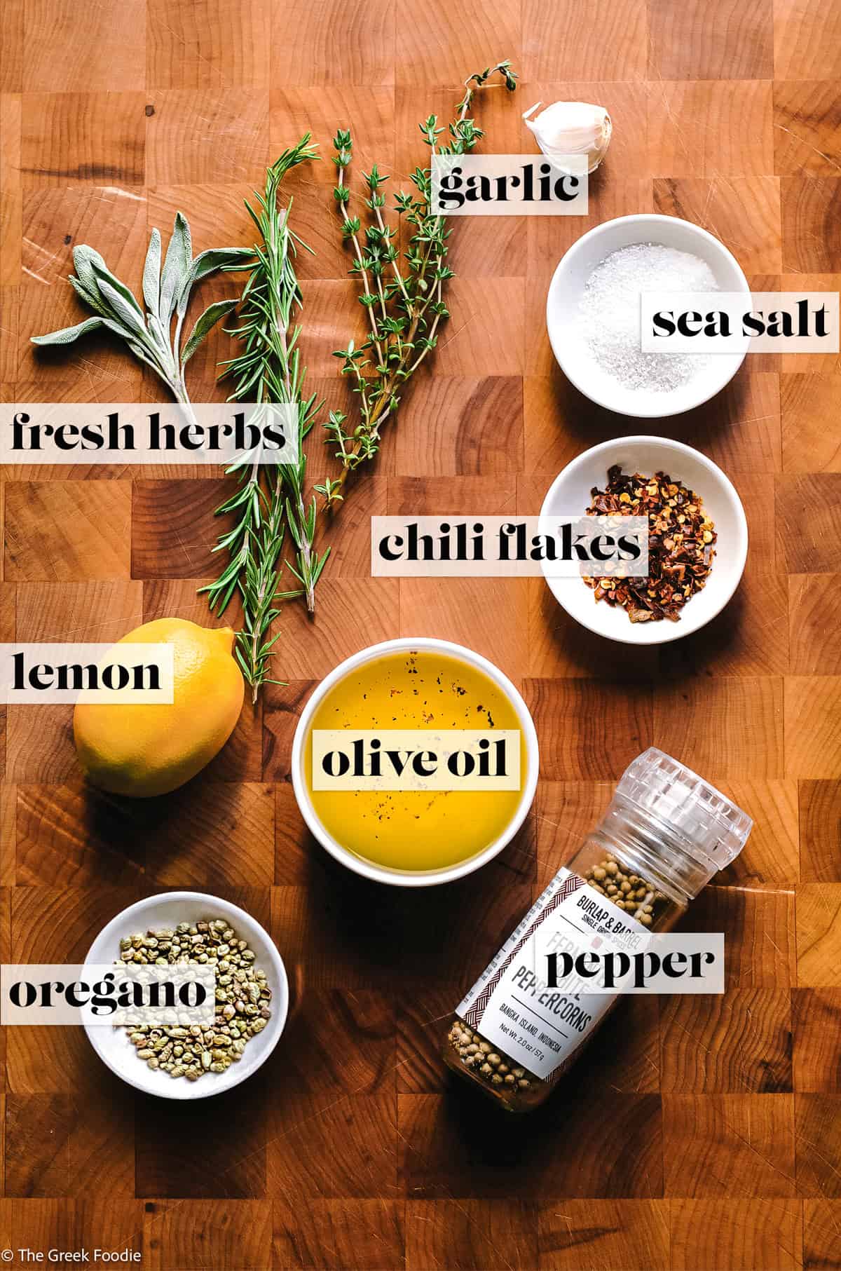 Herbs, seasonings, olive oil and a lemon, ingredients to make Ingredients for making olive oil bread dip.