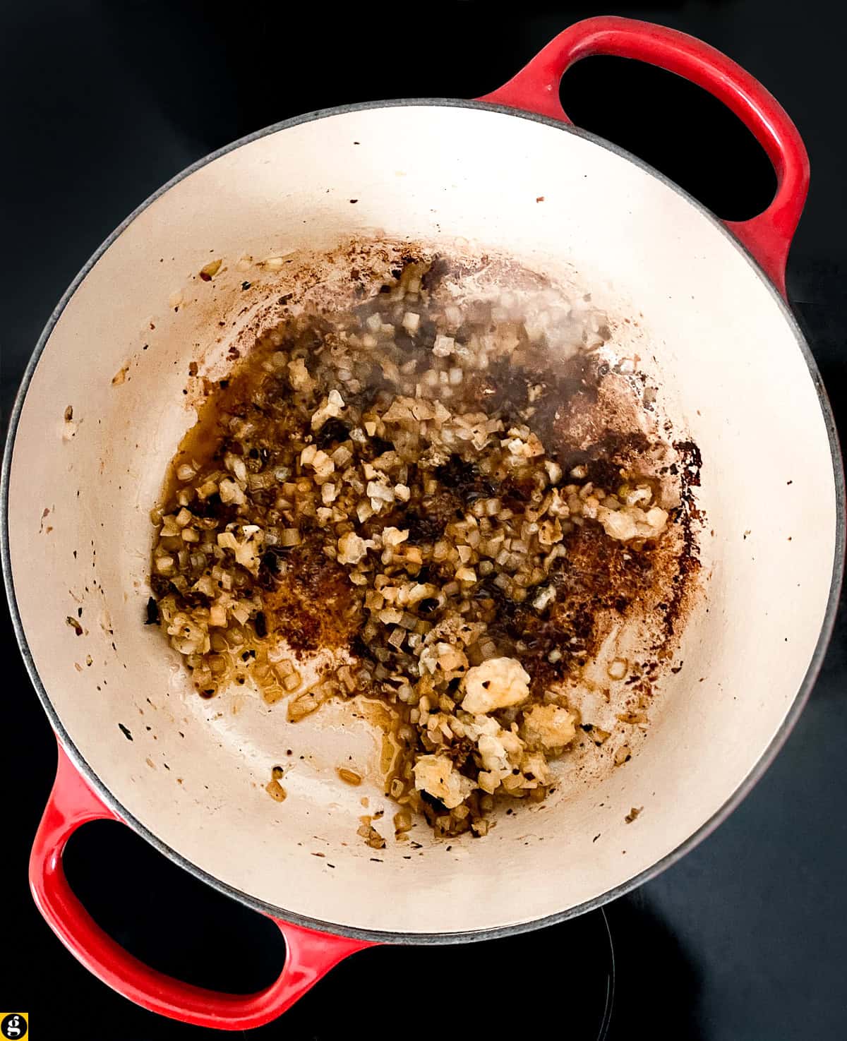 Diced onion sautéing in the browned bits left from the meatballs in a Dutch oven.
