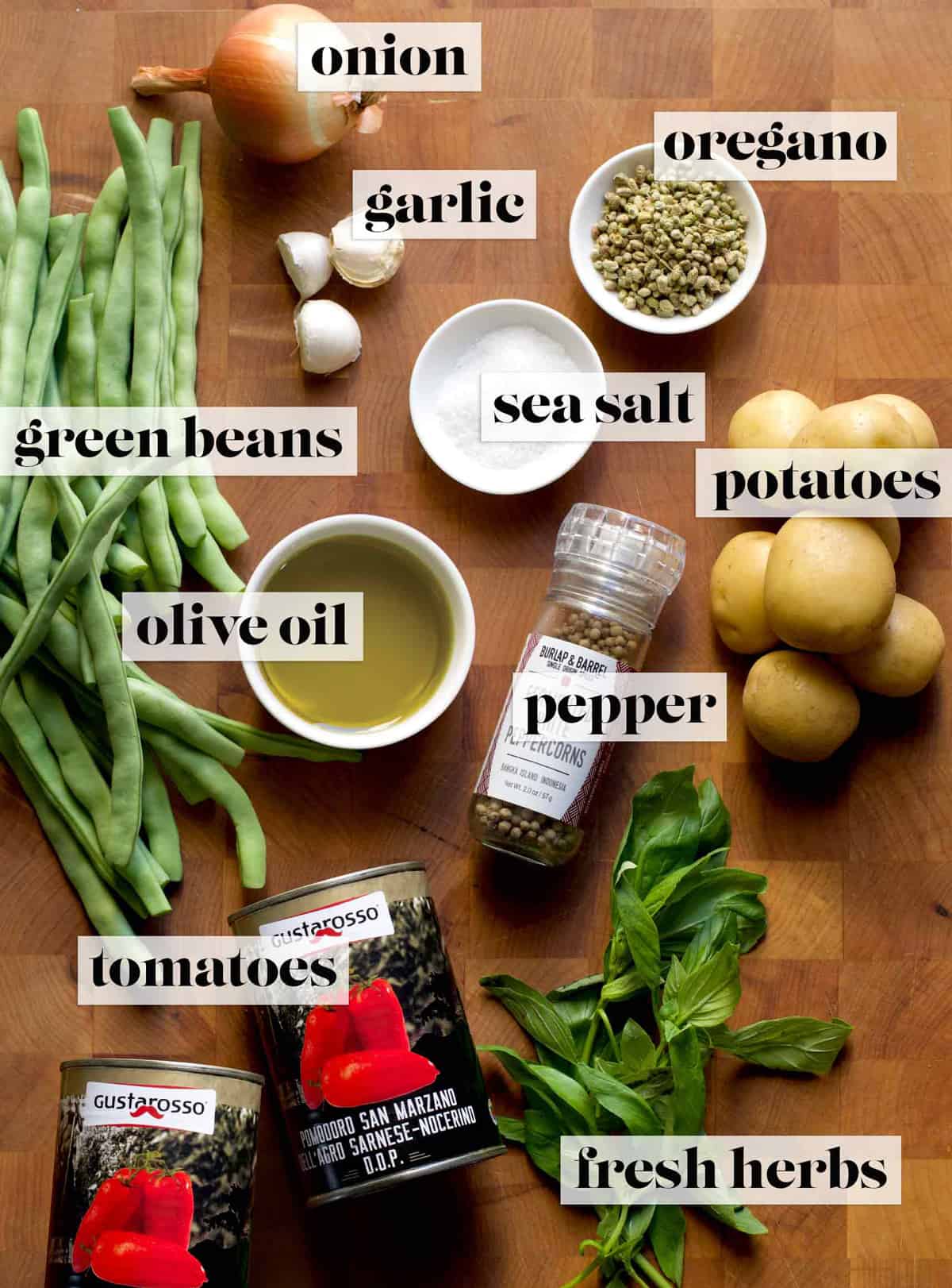 Ingredients for making fasolakia / greek beans in tomato sauce on a butcher block. 