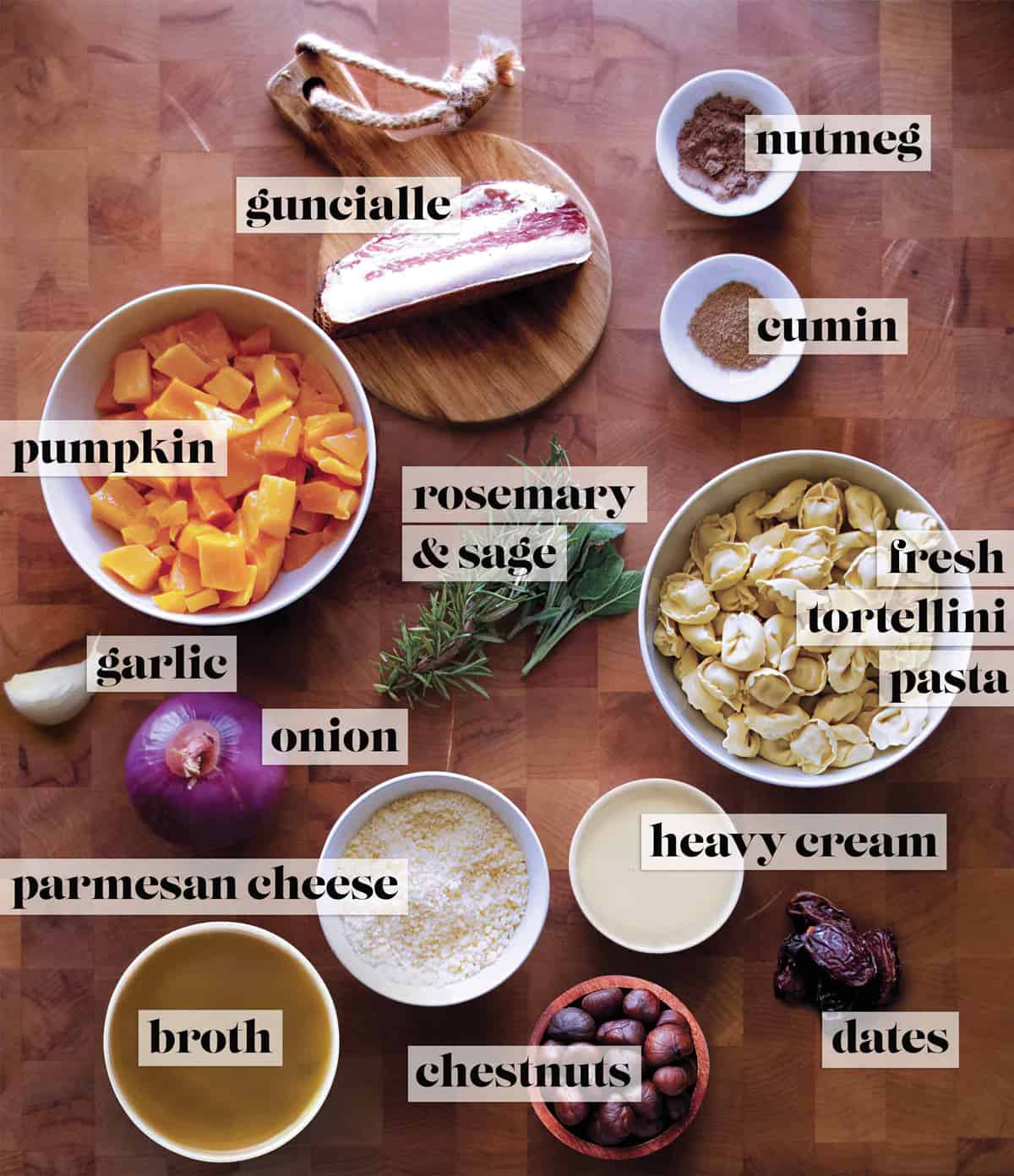 All the ingredients for making pumpkin stew on a butcher block.
