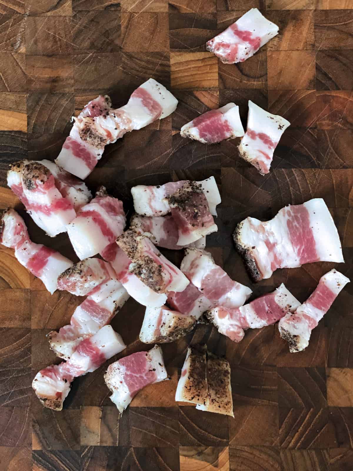 Gunciale cut in bite size pieces on a butcher block.