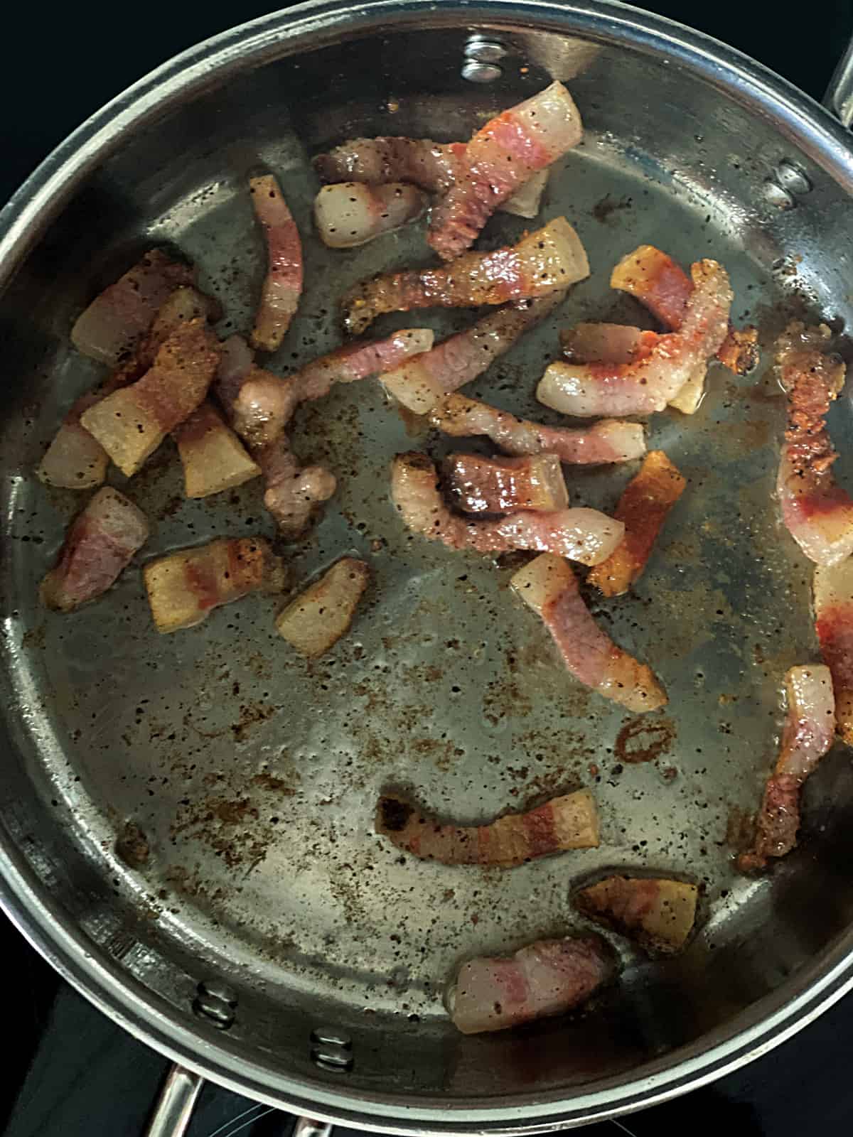 Guinciale pieces in a deep sauce pan.