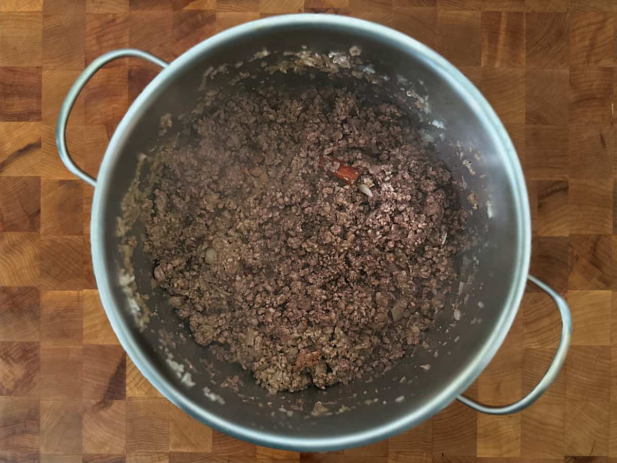 A stock pot with browned ground beef.