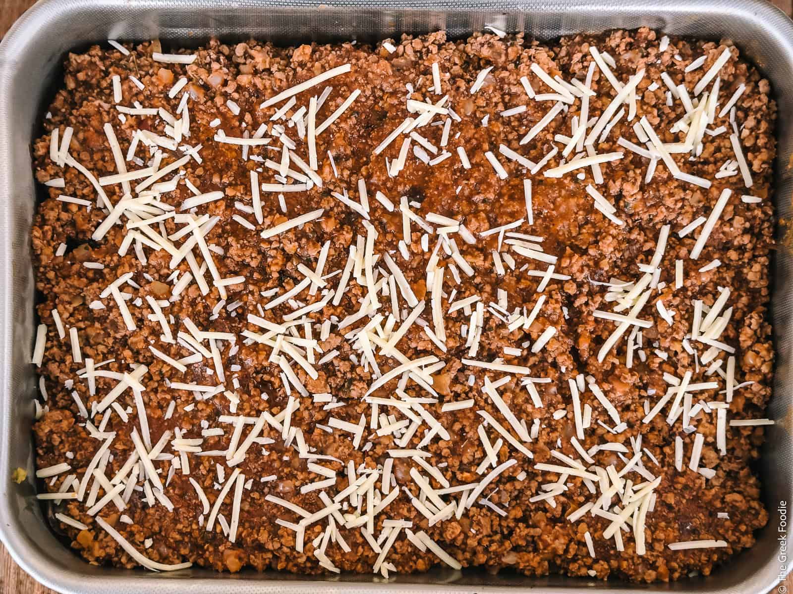 A layer of meat ragu in a baking pan for Greek moussaka