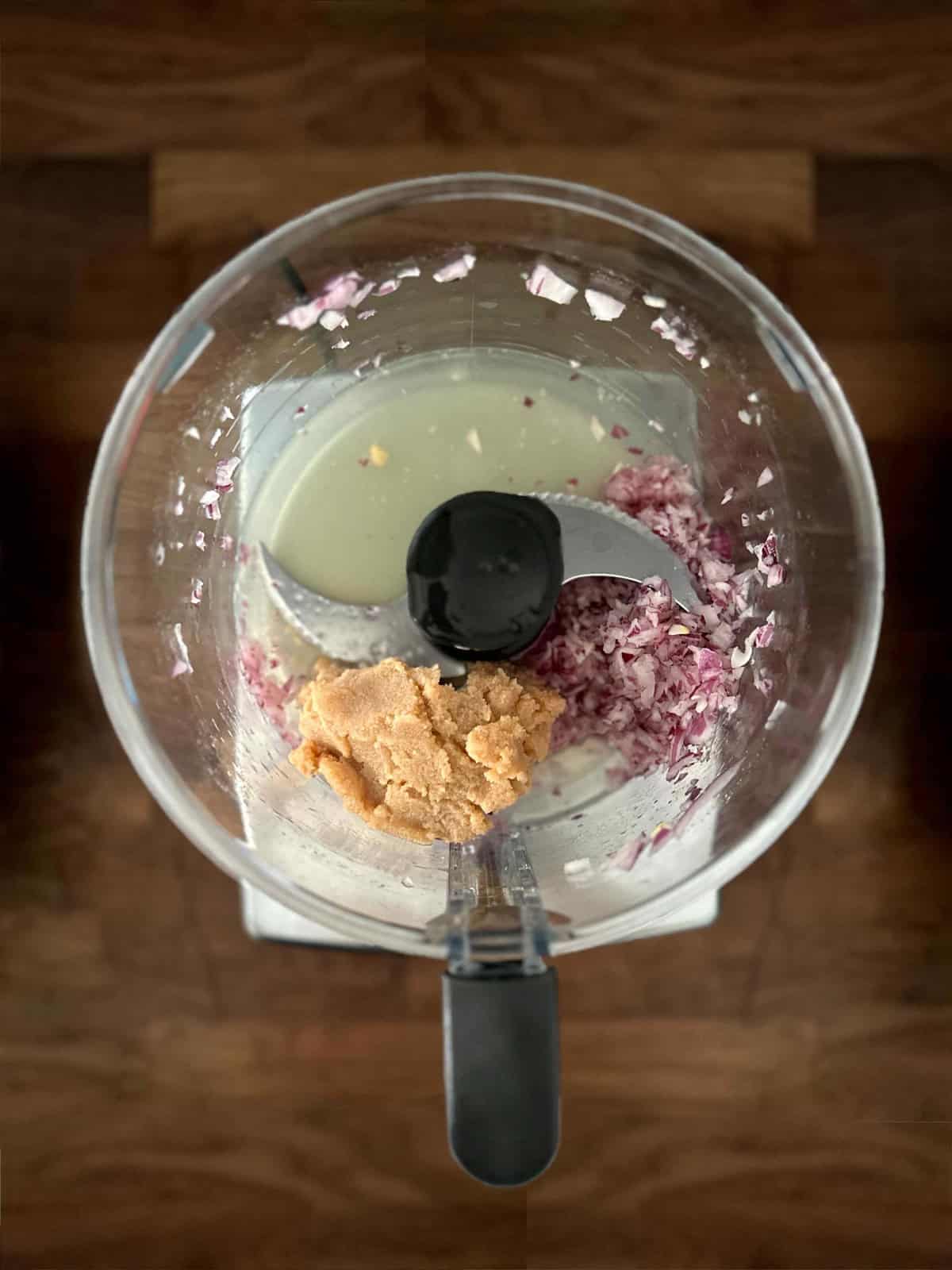 Fish roe and grated onion in a food processor — first step of making taramosalata