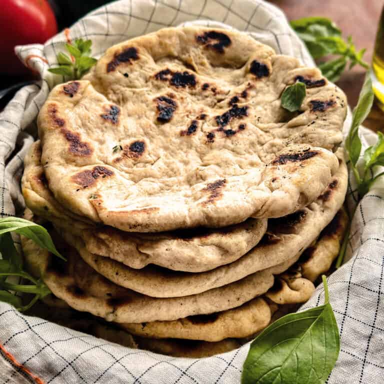 Greek pita bread stacked in a cloth napkin