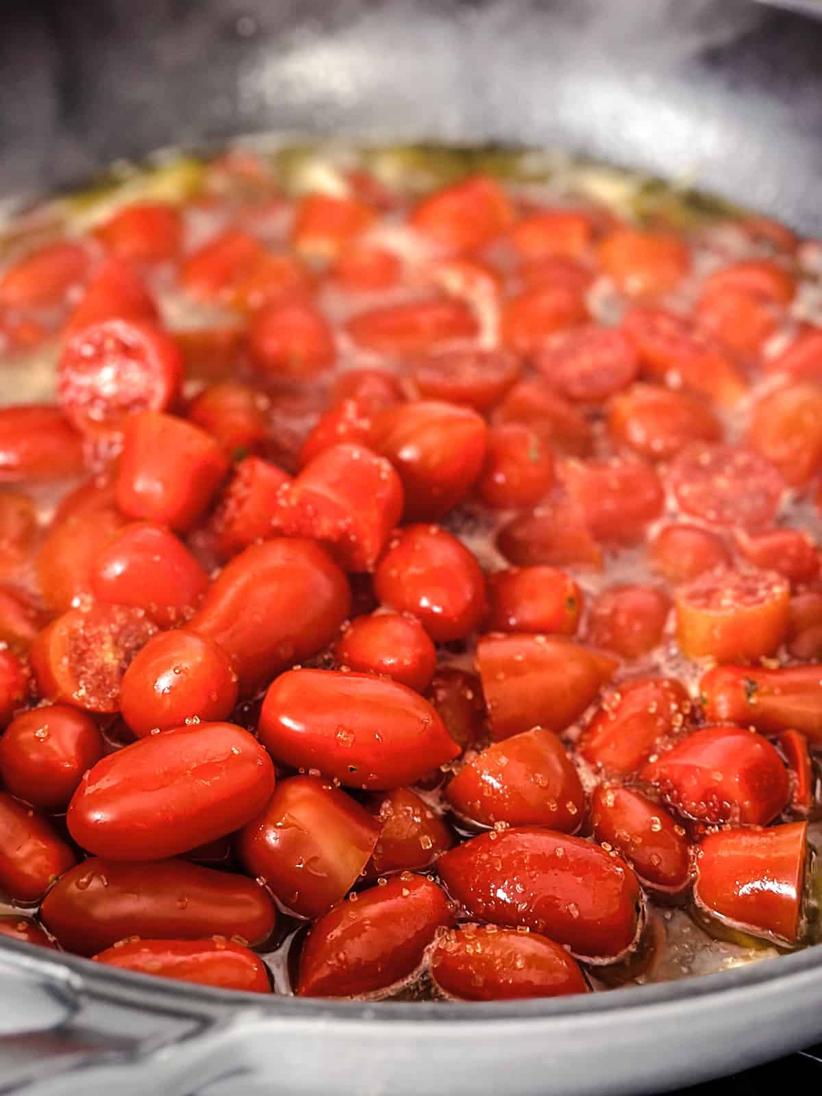 Cherry tomatoes in a deep large sauté pan.